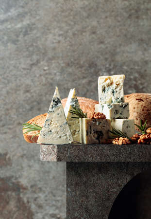 Blue cheese with walnuts, bread, and rosemary. Copy space.