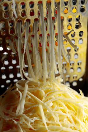 Grated cheese and grater. Concept: Italian cuisine, cheese, restaurant, and food. Selective focus.の写真素材