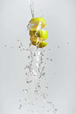 Fresh lime in a splash on a white background.の写真素材