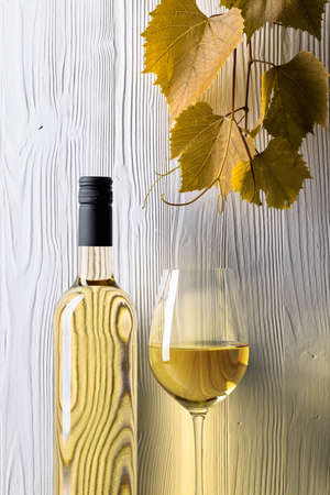 White wine and grapevine on a white wooden background. Copy space.の写真素材