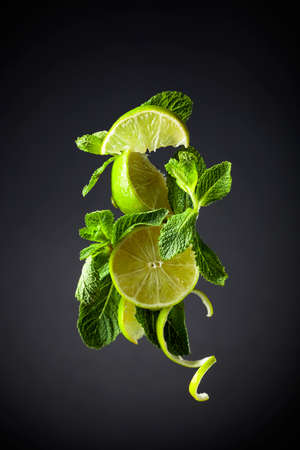 Lime slices and mint on a black background.の写真素材