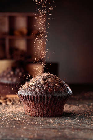 Delicious fresh chocolate muffins on a brown background.の写真素材