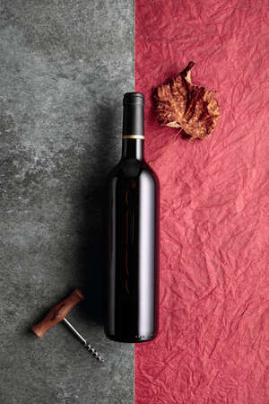 Bottle of red wine with a corkscrew on vintage background. Top view with copy space.の写真素材