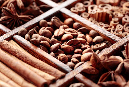 Roasted coffee beans, cinnamon sticks, and anise, in an old wooden box. Selective focus.の写真素材