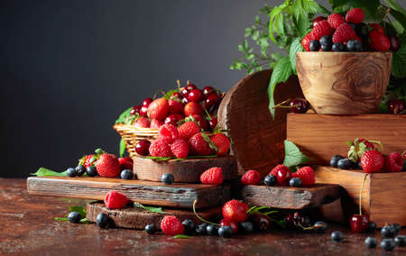 Assorted fresh berries with leaves. Strawberries, raspberries blueberries, and sweet cherries on an...