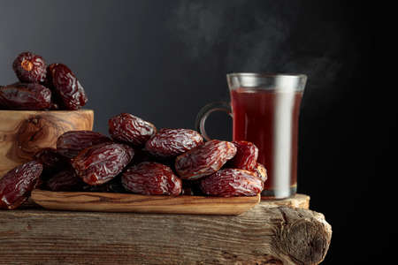 Tea and dried dates on a old wooden table.