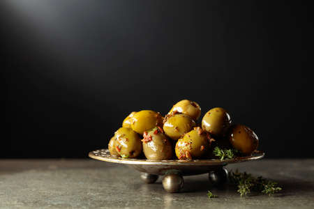 Spicy green olives in olive oil on a black background. Copy space.の写真素材