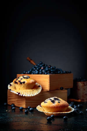 Blueberry muffins and berries in a wooden box. Copy space.の写真素材