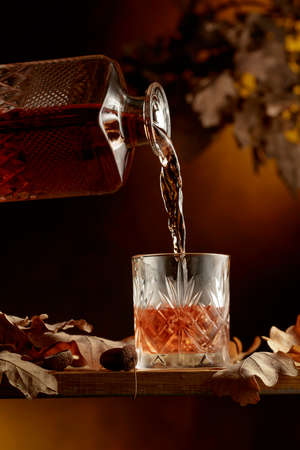 Whiskey is poured into a frozen glass with ice.の写真素材