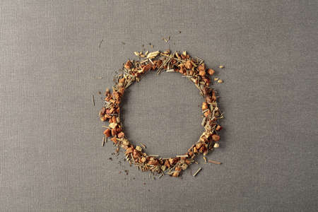 Herbal tea is scattered on a grey background. Round copy space. Top view.の写真素材