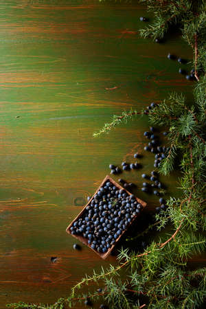 Juniper branches and seeds on a old wooden background. Top view with copy space.の写真素材