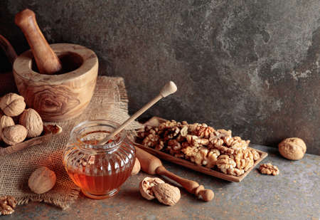 Honey and walnuts on an old kitchen table. Copy space.の写真素材