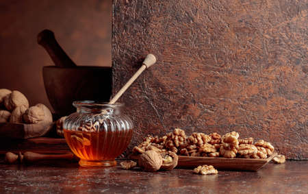 Honey and walnuts on an old kitchen table. Copy space.の写真素材