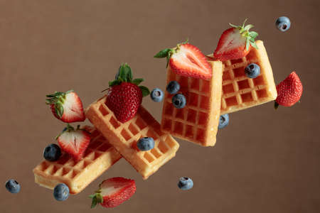 Waffles with blueberries and strawberries. Food levitation.の写真素材