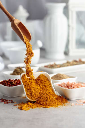Curry is poured into a small bowl. Curry and various spices on a kitchen table.の写真素材