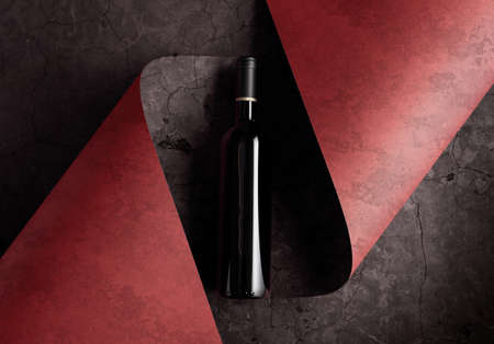 Bottle of red wine on a dark background. Copy space for your text, top view.