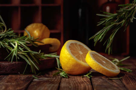 Rosemary and lemon slices on an old wooden table.の写真素材