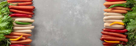 Various sausages with salad,  rosemary, and hot peppers on a concrete background. Concept of the theme of a picnic. Copy space.の写真素材