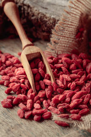 Dried goji berries on an old wooden table.の写真素材