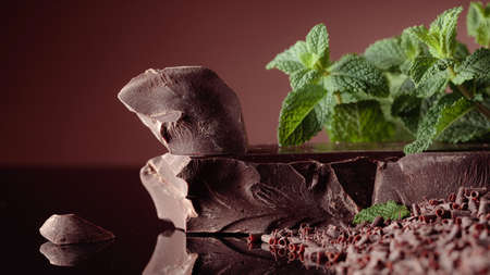 Bitter chocolate with mint on a black reflective background.の写真素材