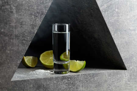 Tequila with lime slices and sea salt on a grey stone background.の写真素材