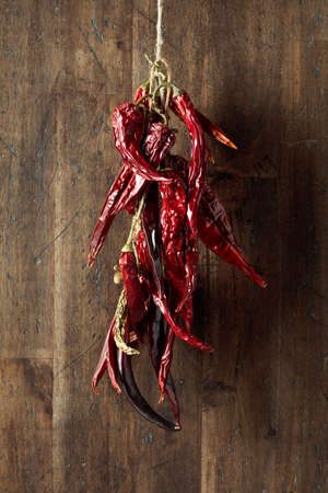 Dried red hot chili pepper on an old wooden background.の写真素材