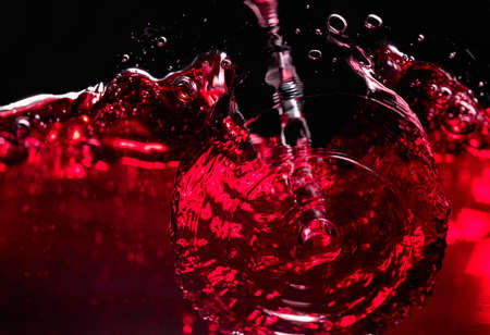 Red wine on black background, abstract splashing. Macro shot.