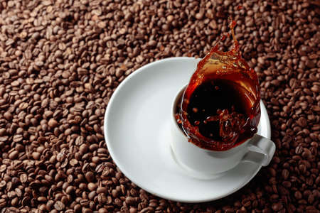 Top view above of black hot coffee in a white ceramic cup. Splashes of black coffee.の写真素材
