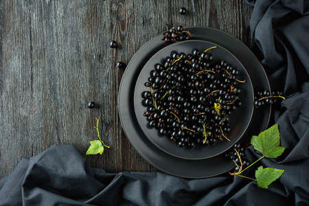 Black currant with leaves on a old wooden table. Top view.の写真素材