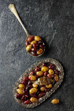 Spicy olives on a black stone table. Top view.の写真素材