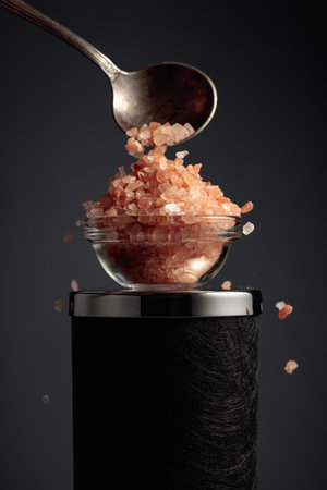 Pink salt is poured into a small glass bowl.の写真素材