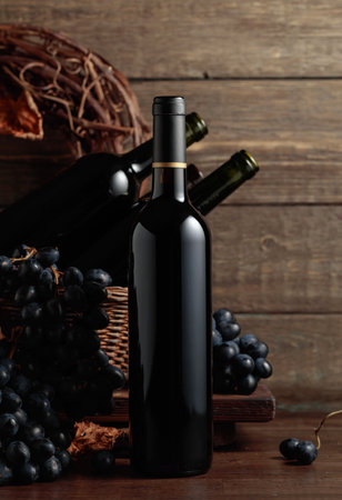 Red wine and blue grapes. Wine and grapes in a vintage setting on an old wooden table.の写真素材