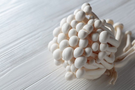 Bunch of Shimeji mushrooms on a white wooden table. Japanese cuisine.