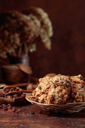 Oatmeal raisin cookies and kitchen utensils on a brown table. Copy space.の写真素材