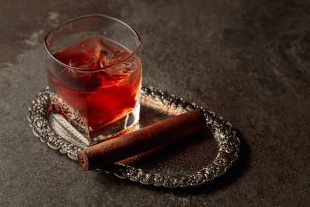 Whiskey with ice and cigar on an old stone table. Copy space.の写真素材