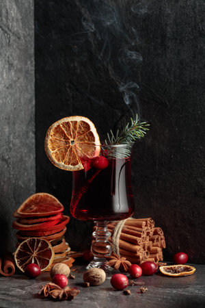 Hot Christmas drink with spices, dried citrus, and cranberries. Smoldering spruce branch in a glass.の写真素材