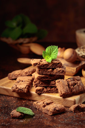 Pieces of fresh brownie with mint on an old table with kitchen utensils.の写真素材