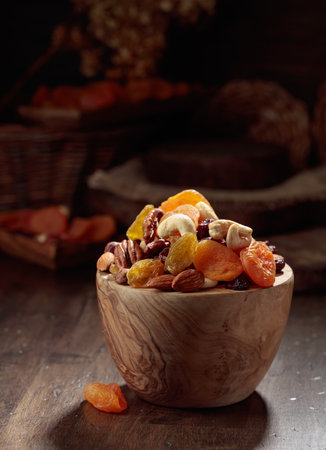 Dried fruits and assorted nuts on an old wooden table.の写真素材