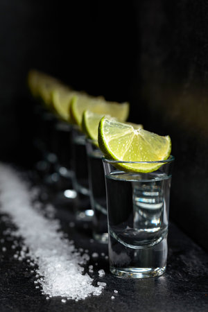Tequila with lime and sea salt on a background of black slate.の写真素材