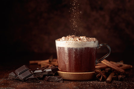 Hot chocolate with whipped cream sprinkled with chocolate crumbs. Hot chocolate with ingredients on a brown table.の写真素材