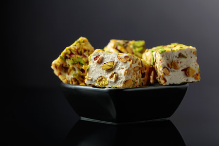 Traditional Turkish delight in a small black dish on a black reflective background.の写真素材