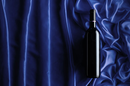 Bottle of red wine on a blue satin background. Top view.の写真素材