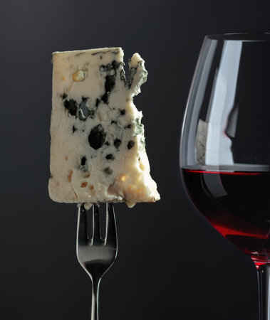 Blue cheese and red wine on a black background.の写真素材