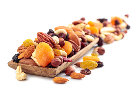 Mix of nuts and dried fruits isolated on a white background. Presented apricots, raisins, walnuts, hazelnuts, cashews, pecans, and almonds.の写真素材