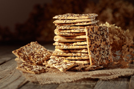 Crispy crackers with sunflower and flax seeds on an old wooden table. Simple healthy food.