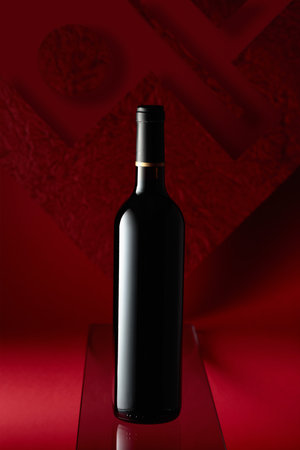 Bottle of red wine on a red background.の写真素材