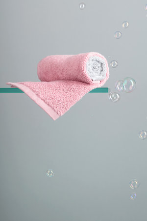 Towel on a glass shelf. Background with bubbles. Concept of the theme of bath and hygiene. Copy space.の写真素材