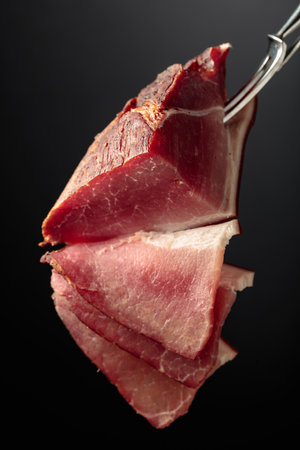 Dry-cured pork fillet on a black background.の写真素材