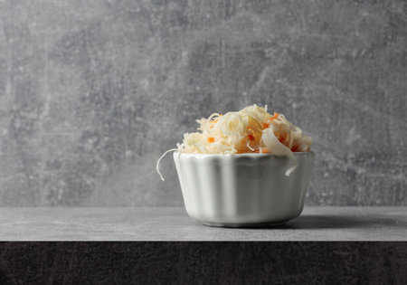 Bowl of sauerkraut with a carrot on a grey stone table. Copy space.の写真素材