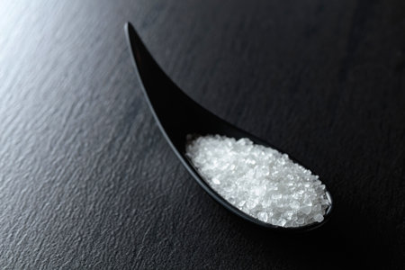 White sea salt on a black ceramic table. Copy space.の写真素材